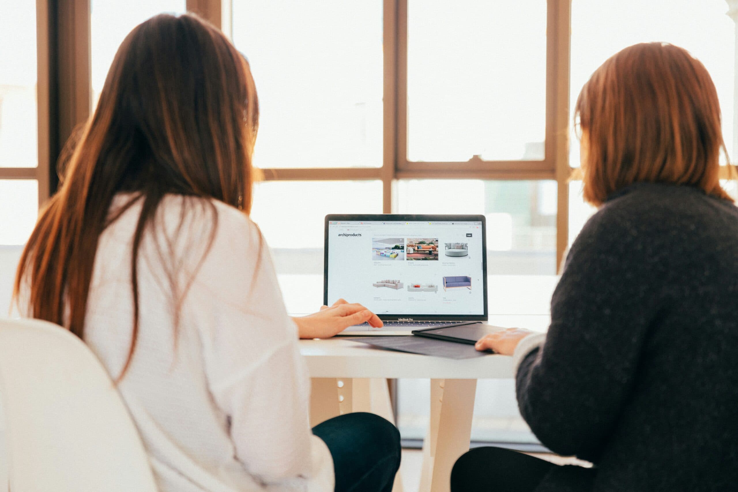 two women working on a laptop together