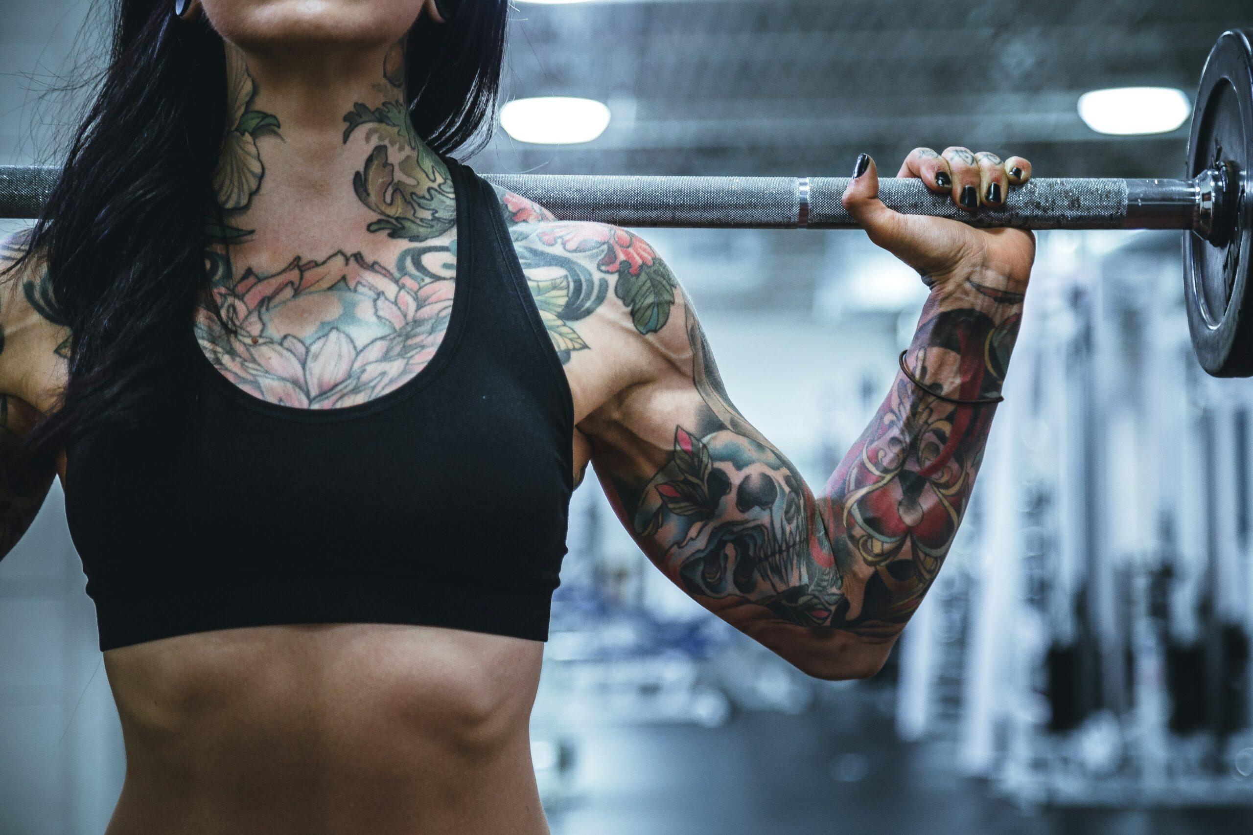 tattooed woman carrying weights